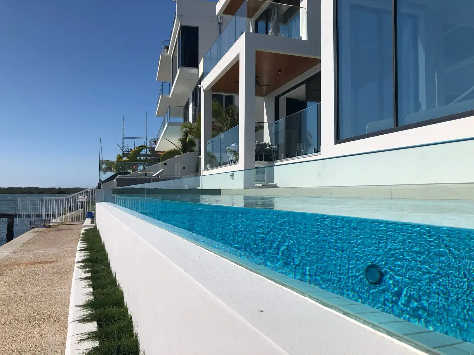 Glass pool fencing and windows at a modern coastal residence